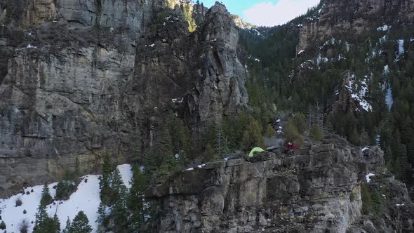 Aerial rotation around a campsite on the edge of a cliff