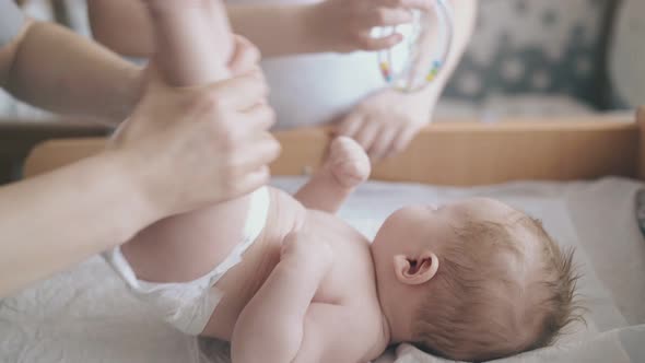 Nurse Raises Infant Boy Legs Practicing Hypertonus Massage