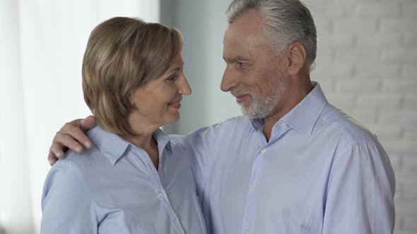 Old Couple Looking at Each Other, Hugging, Man Putting Head Against Woman Neck