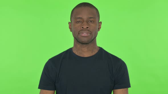 Serious Young African Man on Green Background