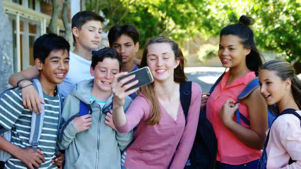 Happy students taking selfie on mobile phone