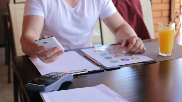 A male customer pays using NFC contactless payment technology on a smartphone.