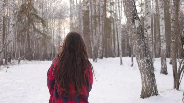 Female in Checkered Shirt Walking in Snowy Park