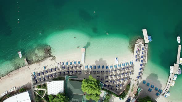 Aerial Azure Beach with Empty Sun Loungers and Boats Balkan Sea Coast Albania