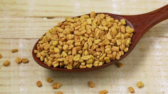 Wooden spoon with fenugreek seeds close up 