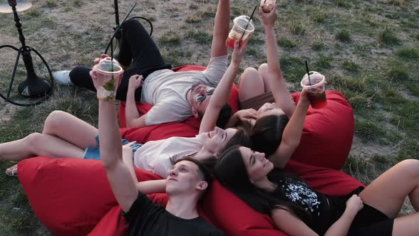 European Friends Are Lying on the Beanbags with Cocktails