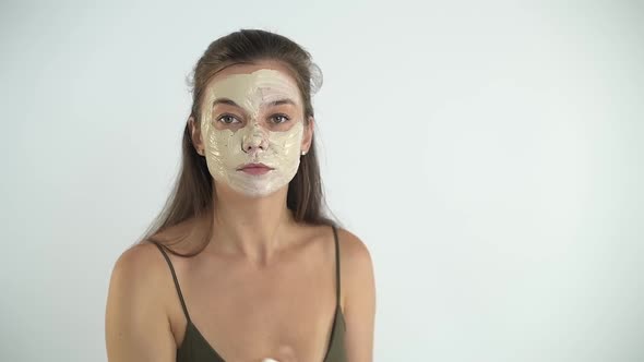 A Young Beautiful Girl Applies a Moisturizing Mask to Her Face with a Brush
