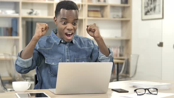 Man Celebrating Success while Working on Laptop