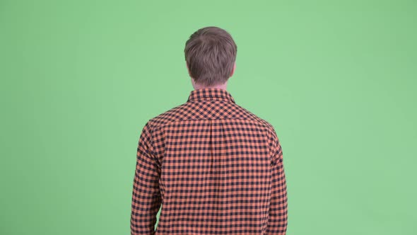 Rear View of Young Hipster Man Pointing Finger