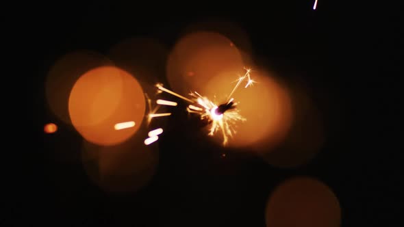 Lit party sparkler sparkling on black background