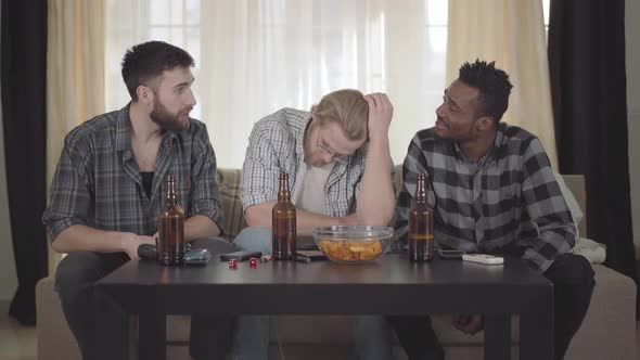 Two Caucasian and One African American Men Sitting on the Sofa