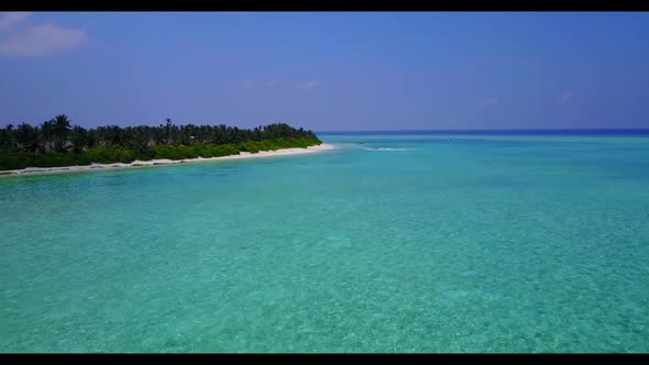 Aerial landscape of tranquil tourist beach vacation by shallow ocean and clean sandy background of a