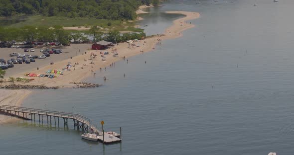 Aerial Panning Shot of Pier and People at the Beach in Cold Spring Harbor