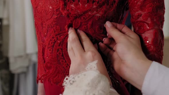 Closeup of a Seamstress Pinning a Lace Dress Fitting in a Sewing Workshop