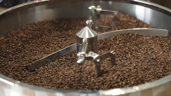 Close View of Mixing Roasted Coffee Beans in Professional Equipment. Slowly.