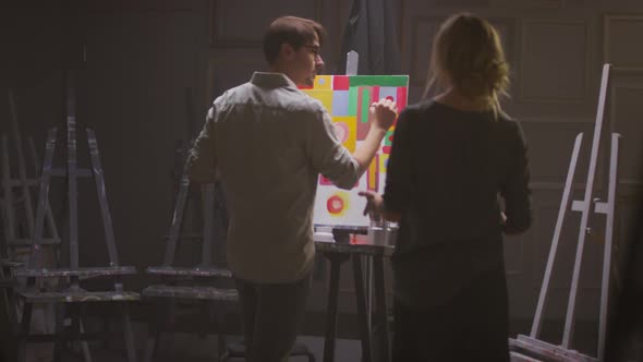 Couple Of Painters In Dark Art Studio