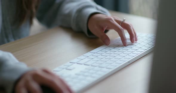 Woman type on desktop computer