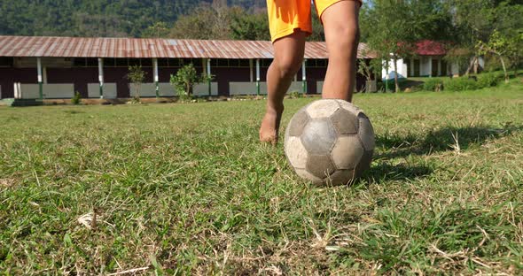 Rural Boy Playing With Old Soccer Ball