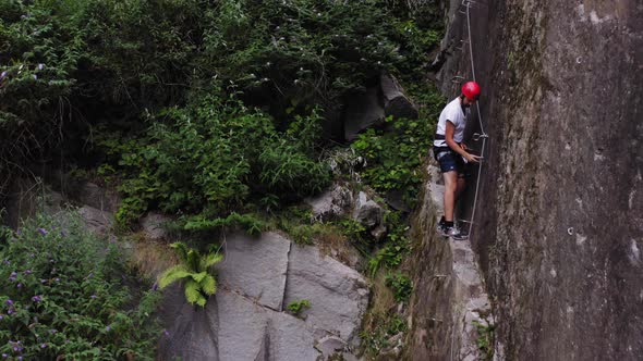 Aerial View Muscular with Red Helmet Rockclimber Climb on Tough Sport Route in