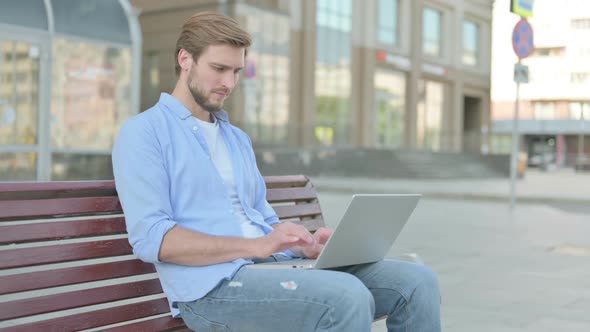 Busy Man Using Laptop Sitting Outdoor on Bench