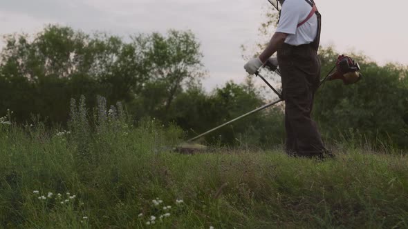 Male Gardener Working with Professional Equipment in Garden