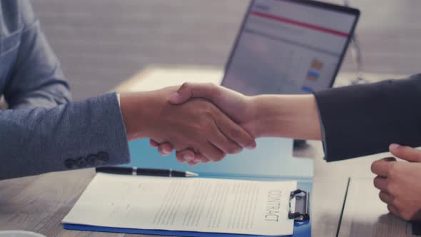 Close up of Asian businessman shaking hands partnership deal business in the office.