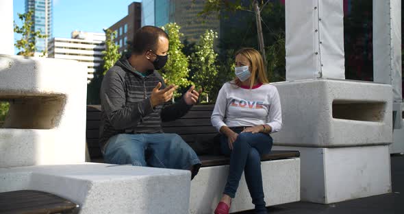 Couple Sitting on Bench with Mask Talking