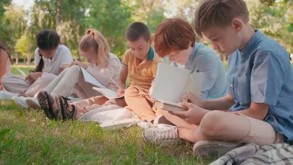 Children Drawing in Notebooks in Park during Outdoor Lesson