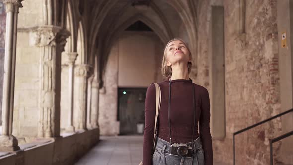 Female Woman Tourist Traveler with Vintage Camera Visiting and Exploring Ancient Monastery Church