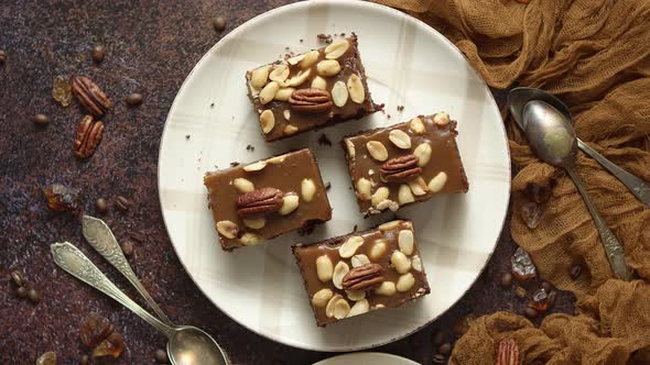 Chocolate Cake with Caramel Frosting, Pecans and Hot Coffee, on Rustic Background. Freshly Baked