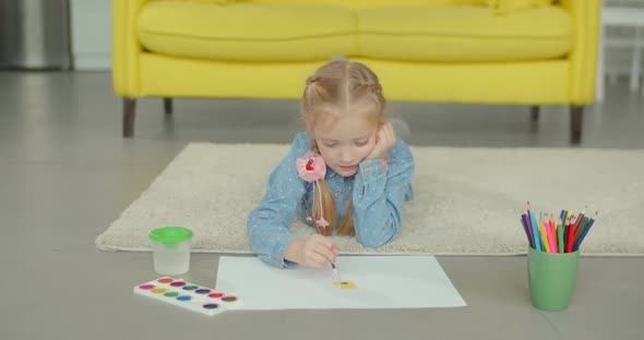 Little Girl Painting with Paintbrush and Paints