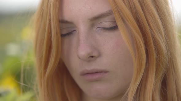 Close-up Portrait of Young Confident Woman with Red Hair and Green Eyes Looking at the Camera