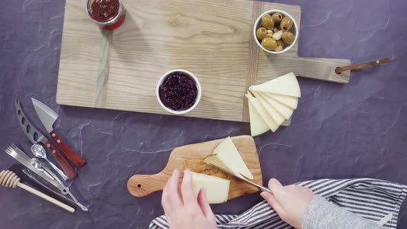 Time lapse. Flat lay. Arranging gourmet cheese, crakers, and fruits on a board for a large cheese bo