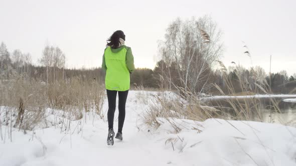 Woman Running in Snow in Winter