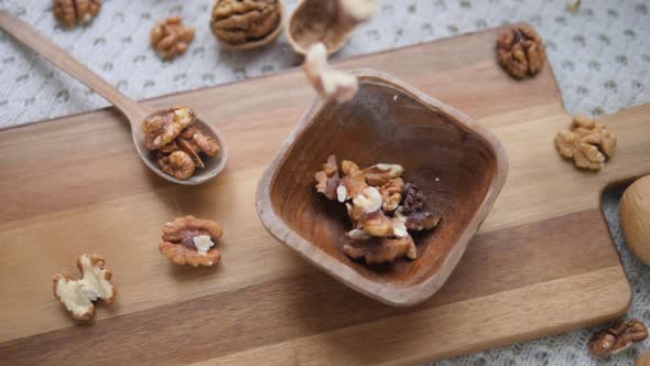 Walnuts Falling In Wooden Bowl. Slow Motion.