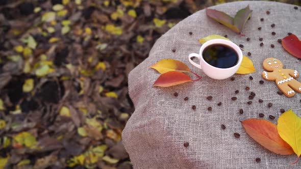 Gingerbread Man and Cup of Coffee Near Autumn Leaves