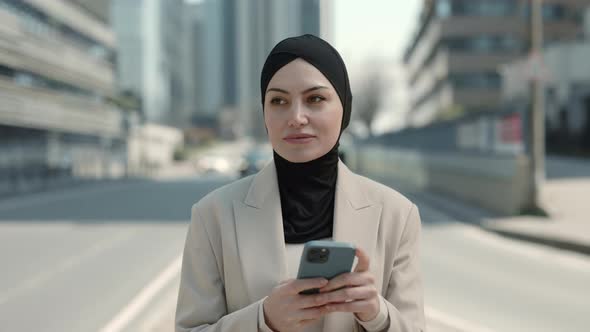 Business Woman in Hijab Using Cell Phone While Walking