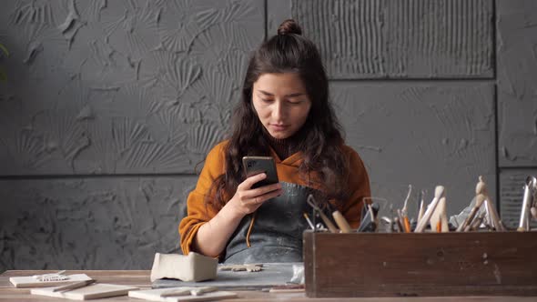 Young Asian Potter Woman Working on Details of a Clay Handcraft Piece