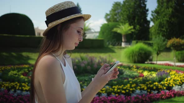 Girl Tourist Using Mobile in the Park of Lednice Palace Czechia