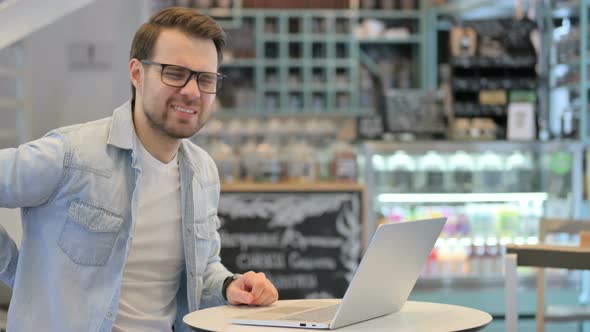 Man Having Back Pain While Working on Laptop