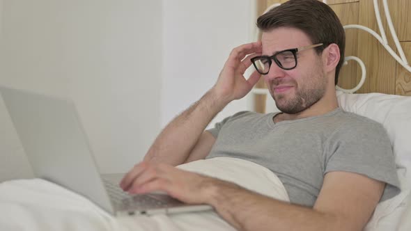 Beard Young Man Having Headache on Laptop in Bed