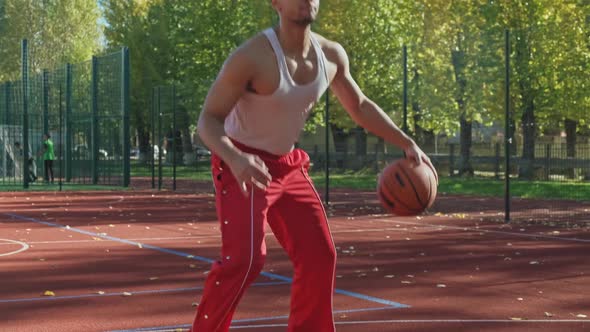 Man Training Basketball at Sunny Weather