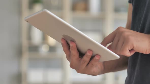 Businessman Browsing Internet on Tablet PC Sitting on Couch