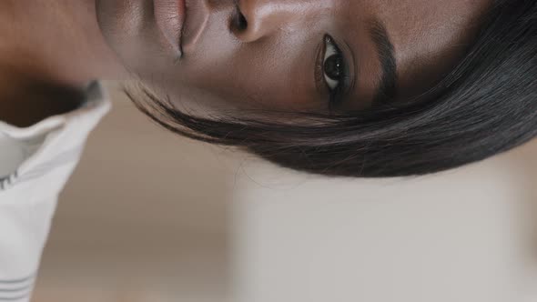 Vertical View Closeup Half Female Face Serious Young African American Woman with Brown Eyes Looking