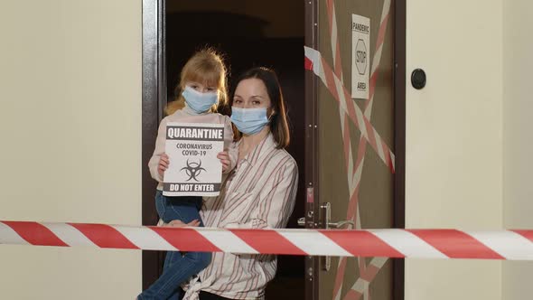 Sick Mother with Kid Daughter in Medical Masks Opening Home Door Coronavirus Quarantine Lockdown