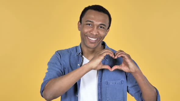 Handmade Heart By Young African Man Yellow Background