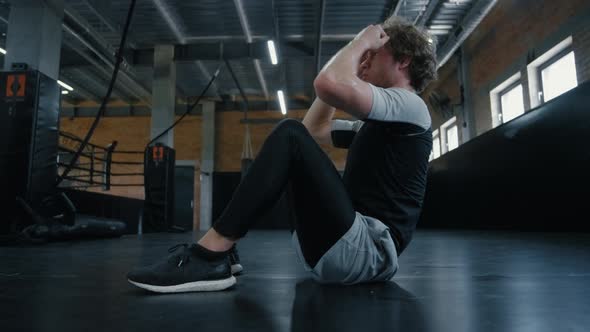 Eager Sportsman Doing Crunches at Gym. Fighter Warming Up in Sport Club