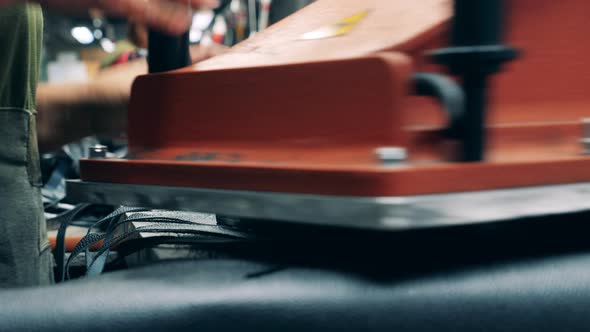 A Worker Is Cutting Out Pieces of Rubber To Make Shoes