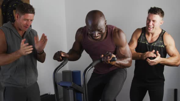 Diverse group of three fit men cross training inside gym