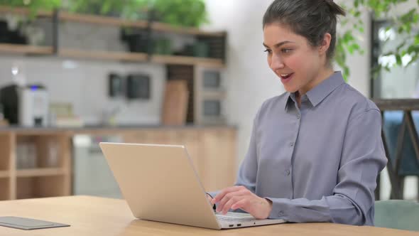 Successful Young Indian Woman Celebrating on Laptop